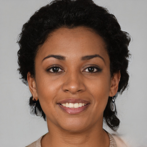 Joyful black young-adult female with short  black hair and brown eyes