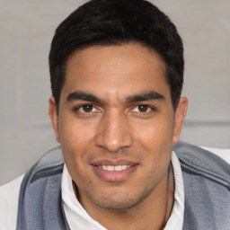 Joyful white young-adult male with short  black hair and brown eyes