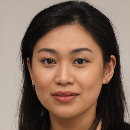 Joyful asian young-adult female with long  brown hair and brown eyes