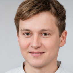 Joyful white young-adult male with short  brown hair and grey eyes