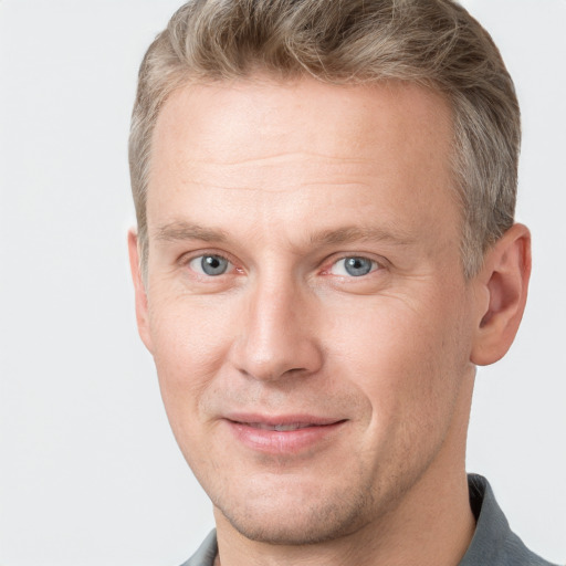 Joyful white adult male with short  brown hair and grey eyes