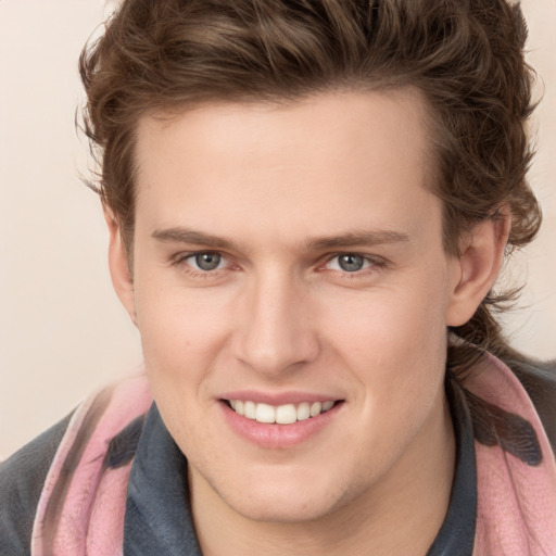 Joyful white young-adult male with medium  brown hair and grey eyes