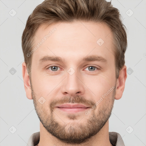 Joyful white young-adult male with short  brown hair and grey eyes