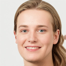 Joyful white young-adult female with long  brown hair and blue eyes