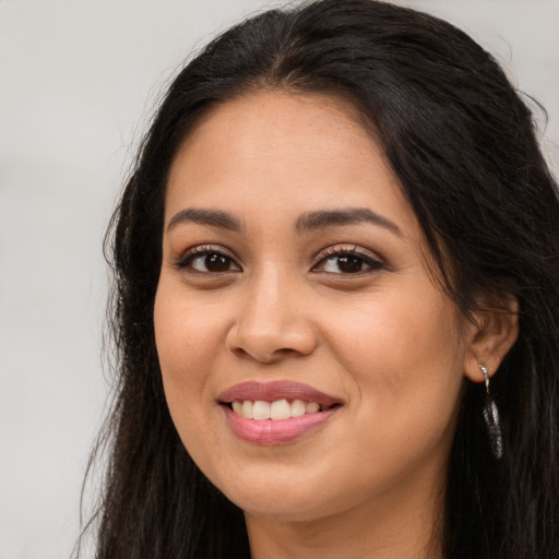 Joyful latino young-adult female with long  brown hair and brown eyes