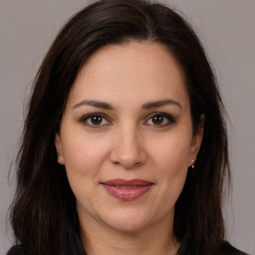 Joyful white adult female with long  brown hair and brown eyes