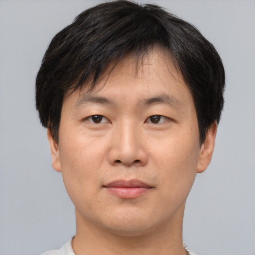 Joyful asian young-adult male with short  brown hair and brown eyes