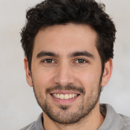 Joyful white young-adult male with short  black hair and brown eyes