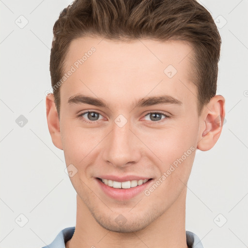 Joyful white young-adult male with short  brown hair and grey eyes