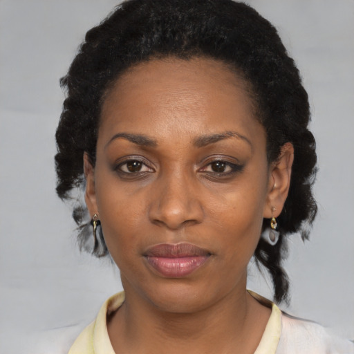Joyful black adult female with short  black hair and brown eyes