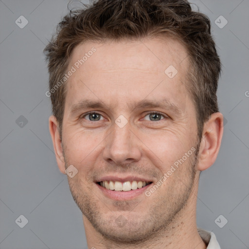 Joyful white adult male with short  brown hair and grey eyes