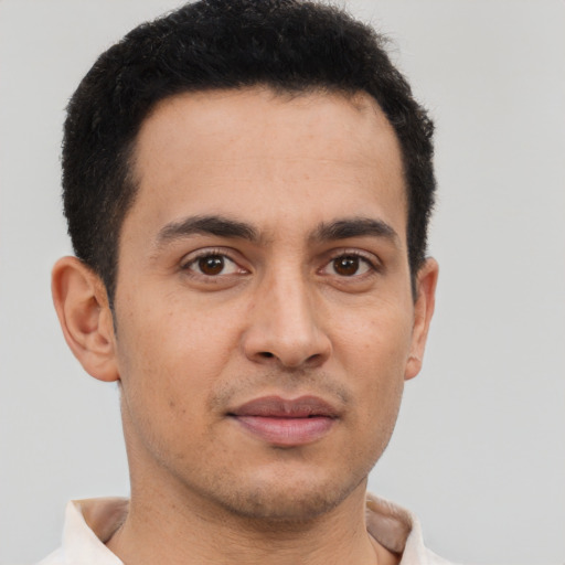 Joyful latino young-adult male with short  brown hair and brown eyes