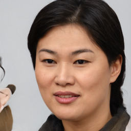 Joyful asian young-adult female with medium  brown hair and brown eyes