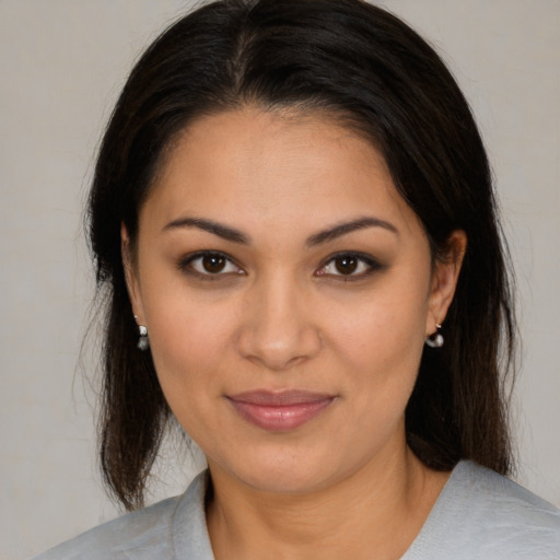 Joyful latino young-adult female with medium  brown hair and brown eyes