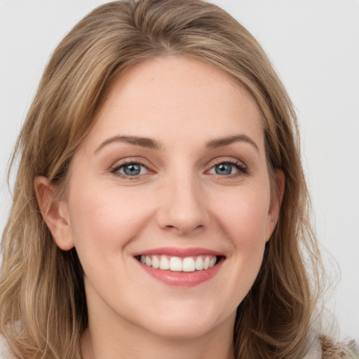 Joyful white young-adult female with long  brown hair and blue eyes