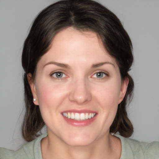 Joyful white young-adult female with medium  brown hair and green eyes