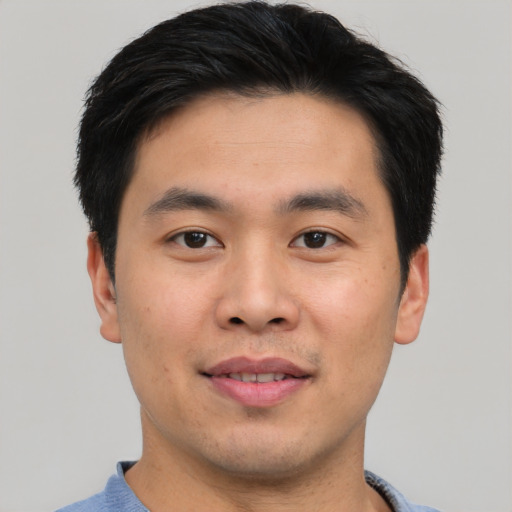 Joyful asian young-adult male with short  black hair and brown eyes