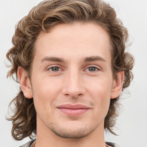 Joyful white young-adult male with medium  brown hair and grey eyes