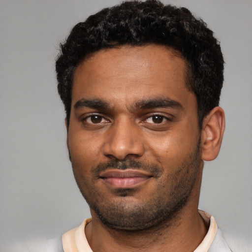 Joyful black young-adult male with short  black hair and brown eyes