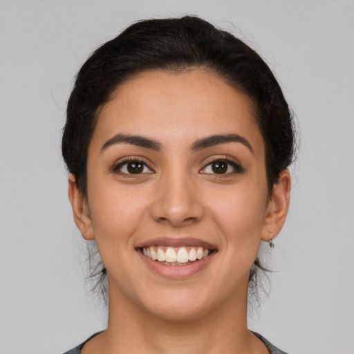 Joyful latino young-adult female with long  brown hair and brown eyes