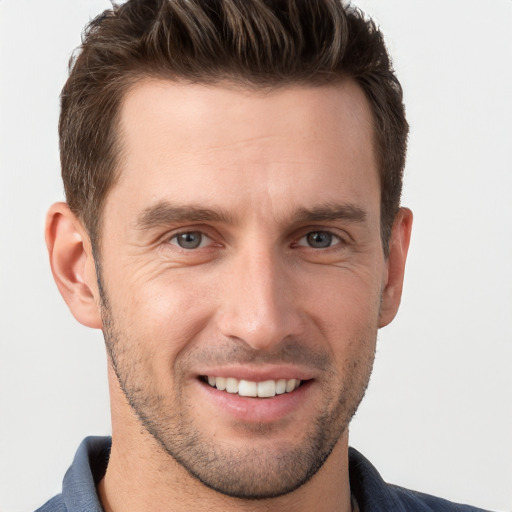 Joyful white young-adult male with short  brown hair and grey eyes