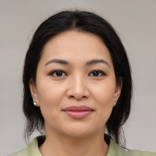 Joyful asian young-adult female with medium  brown hair and brown eyes