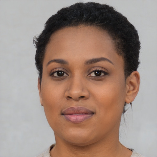Joyful black young-adult female with short  brown hair and brown eyes