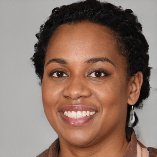 Joyful black young-adult female with medium  brown hair and brown eyes