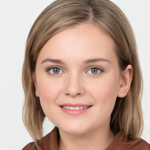 Joyful white young-adult female with medium  brown hair and blue eyes