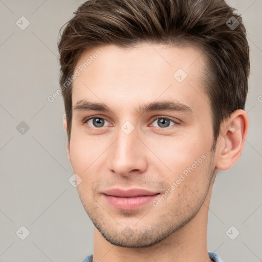 Joyful white young-adult male with short  brown hair and grey eyes