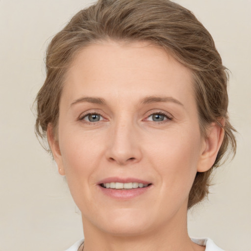 Joyful white young-adult female with medium  brown hair and grey eyes