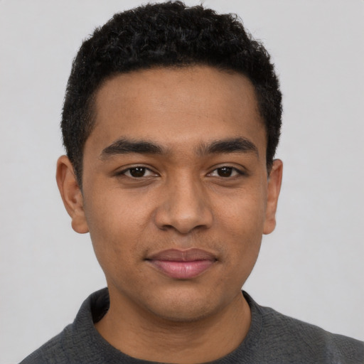 Joyful black young-adult male with short  black hair and brown eyes