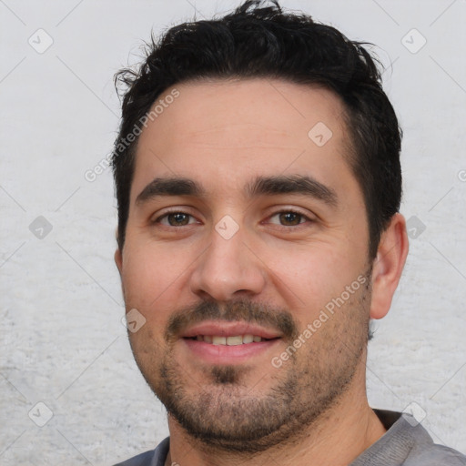 Joyful white young-adult male with short  black hair and brown eyes