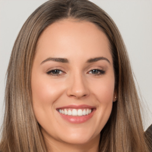 Joyful white young-adult female with long  brown hair and brown eyes