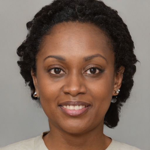 Joyful black young-adult female with short  brown hair and brown eyes