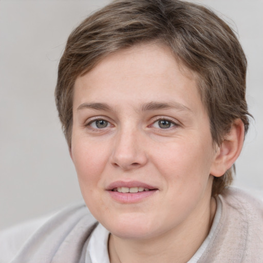 Joyful white young-adult female with short  brown hair and grey eyes