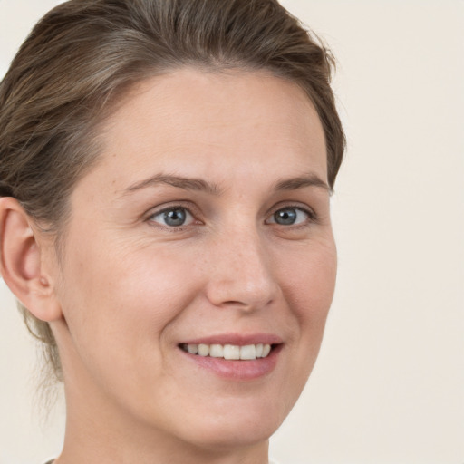 Joyful white adult female with medium  brown hair and grey eyes