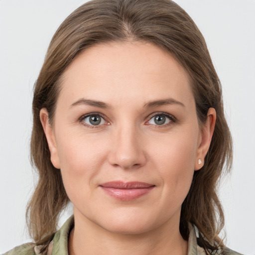 Joyful white young-adult female with medium  brown hair and grey eyes