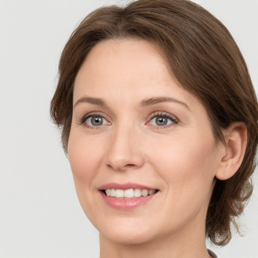 Joyful white young-adult female with medium  brown hair and green eyes