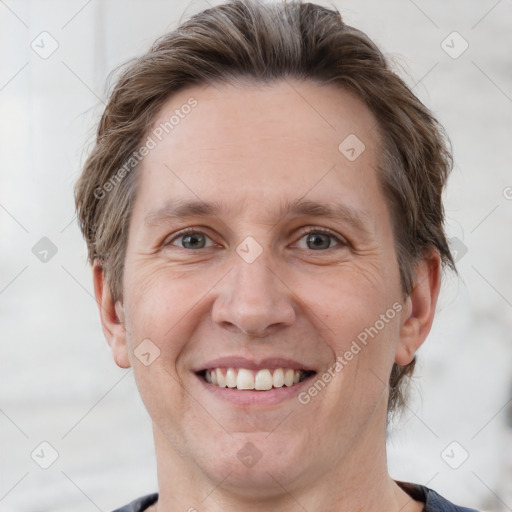 Joyful white adult male with short  brown hair and grey eyes