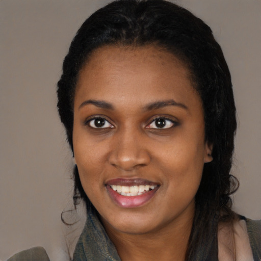 Joyful black young-adult female with long  black hair and brown eyes