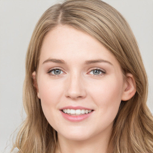 Joyful white young-adult female with long  brown hair and blue eyes