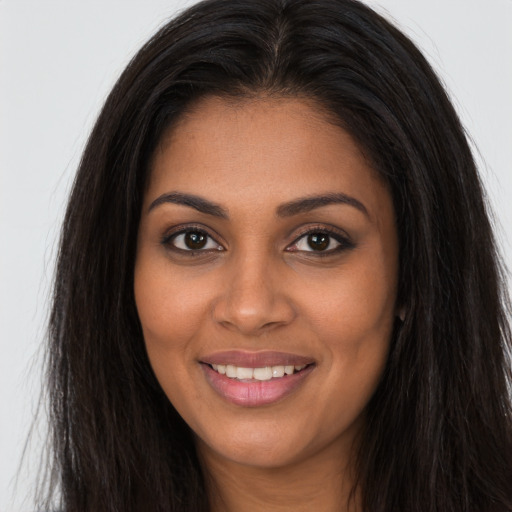 Joyful black young-adult female with long  brown hair and brown eyes