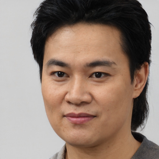 Joyful asian young-adult male with medium  black hair and brown eyes