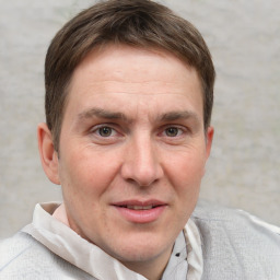 Joyful white adult male with short  brown hair and grey eyes