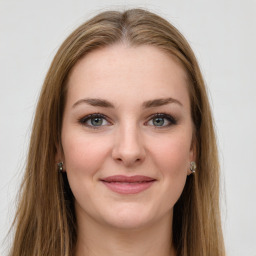 Joyful white young-adult female with long  brown hair and green eyes