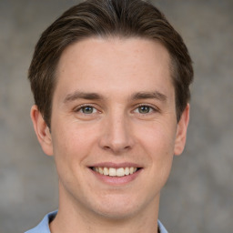 Joyful white young-adult male with short  brown hair and grey eyes