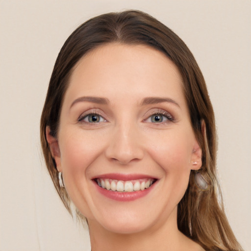 Joyful white young-adult female with long  brown hair and blue eyes