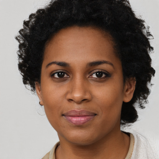 Joyful black young-adult female with short  black hair and brown eyes