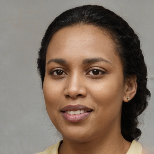 Joyful black young-adult female with medium  black hair and brown eyes